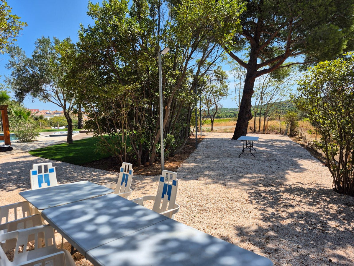 Espace pour grandes tables à l'ombre des pins, parc du Château Réveillon – Bages