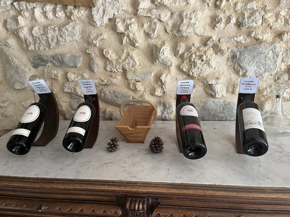 Bouteilles de vin AOP Corbières du Château Réveillon – Bages présentées sur un mur de pierre